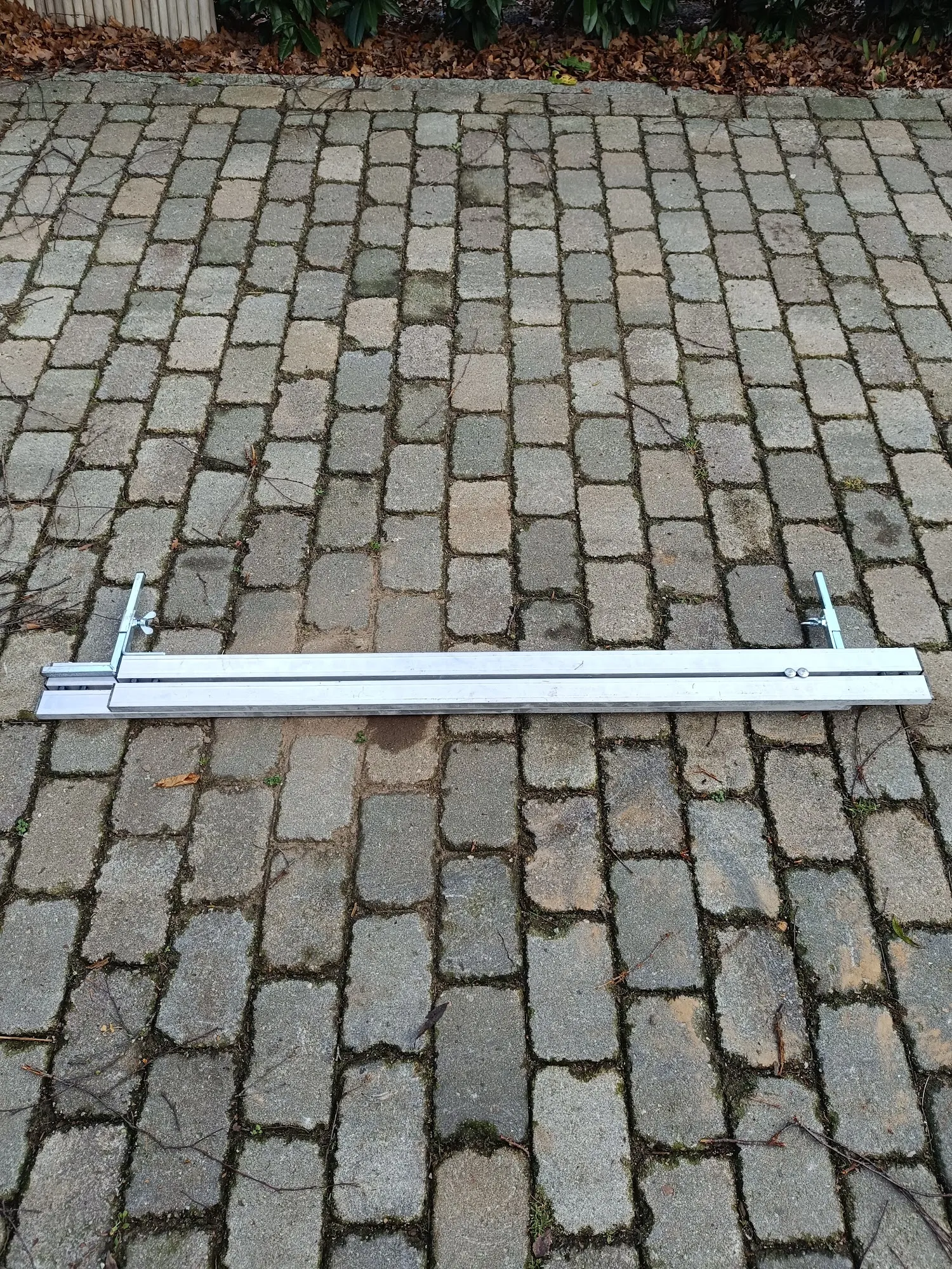Aluminium-Abziehschiene mit verstellbarem Endhalter auf Kopfsteinpflaster