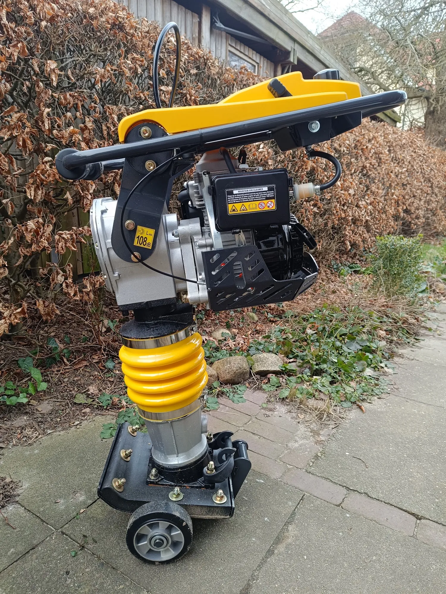 Gelb-schwarzer Vibrationsstampfer auf befestigtem Untergrund